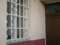 Okno s mrežami pri vstupnom vchode budovy 1